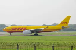 a dhl airplane on the runway at an airport